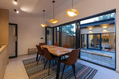 a dining room with a wooden table and chairs at BLOK Wood Cottage in Ivišovo Greblje