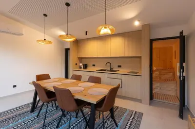 a kitchen with a wooden table and chairs at BLOK Wood Cottage in Ivišovo Greblje