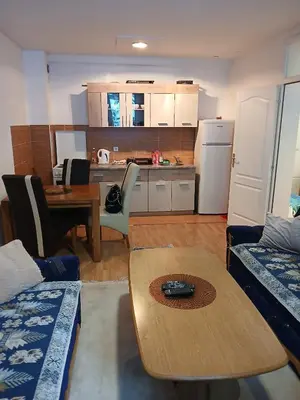 a living room with a table and a kitchen at Apartment Snow Vlašić in Šišava