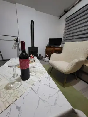 a bottle of wine sitting on a table with two glasses at Studio apartman 
