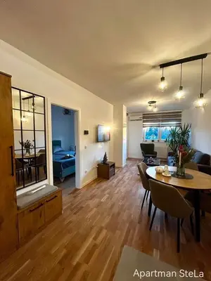 a living room with a table and a living room at SteLa Apartman in Banja Luka