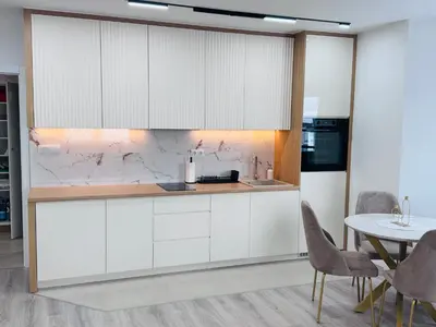 a kitchen with white cabinets and a table at Apartman Jaćimović in Doboj