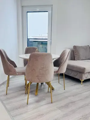 a dining room with a table and chairs and a couch at Apartman Jaćimović in Doboj