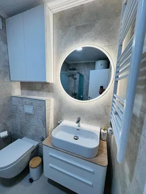 a bathroom with a sink and a toilet and a mirror at Apartman Jaćimović in Doboj