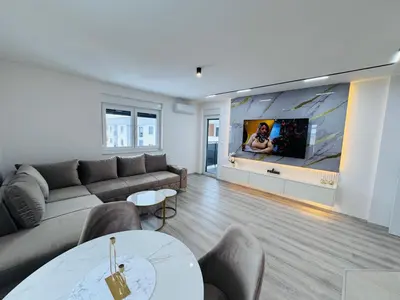 a living room with a couch and a flat screen tv at Apartman Jaćimović in Doboj