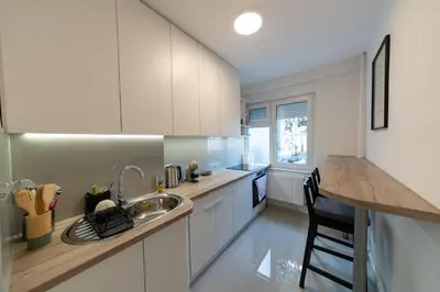 a kitchen with white cabinets and a sink and a counter at Apartman Srna in Banja Luka