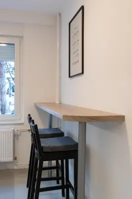 a kitchen with a table and two stools at Apartman Srna in Banja Luka