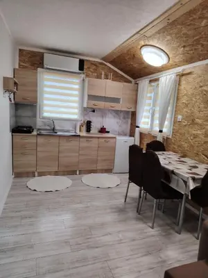 a kitchen and dining room with a table and chairs at Mubina Apartman in Ćukovi