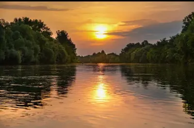 a sunset on a river with the sun setting at Mubina Apartman in Ćukovi