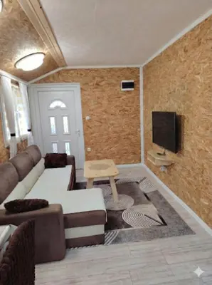 a living room with a couch and a tv at Mubina Apartman in Ćukovi