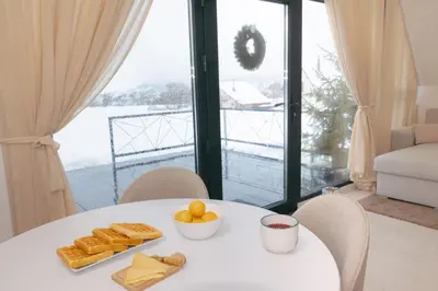 a white table with bread and a bowl of fruit at De Villa Bey in Kupres