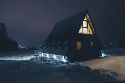 a building with a lit up window at night at De Villa Bey in Kupres