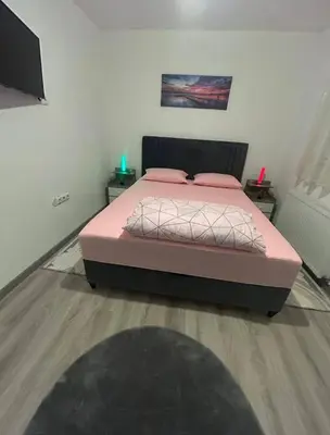 a bedroom with a bed with a pink bedspread at Stan Krndija - Tesanj in Tešanj