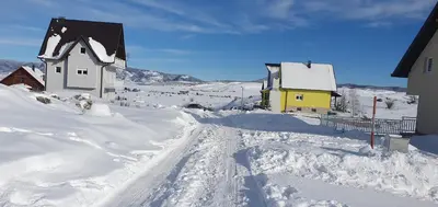 a street covered in snow with houses and buildings at Vikendica Jadranka in Kupres