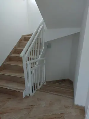 a white staircase with wooden floors in a room at Vikendica Jadranka in Kupres