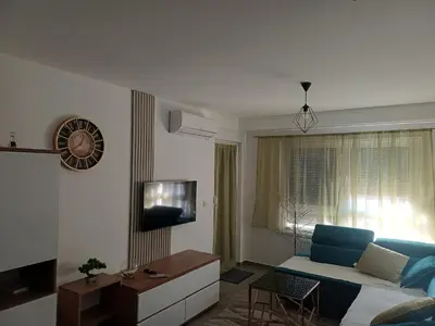 a living room with a blue couch and a tv at Stan na dan Kratos in Banja Luka
