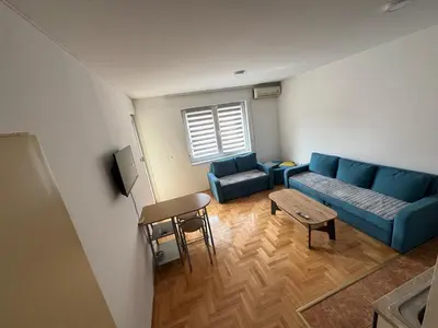 a living room with a blue couch and a table at dvojka in Banja Luka