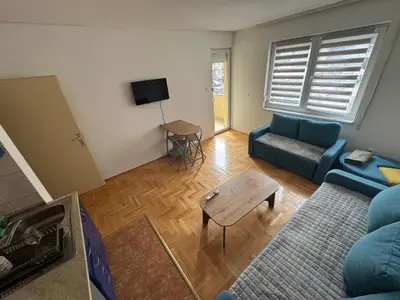 a living room with a blue couch and a table at dvojka in Banja Luka