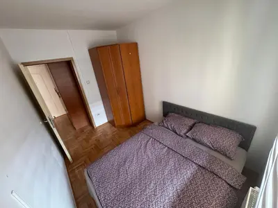 a small bedroom with a bed and a wooden cabinet at dvojka in Banja Luka