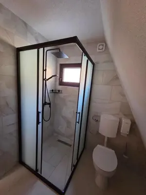 a bathroom with a toilet and a glass shower at Kozara Resort