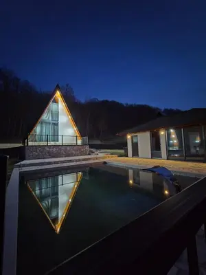 a house with a swimming pool at night at Kozara Resort