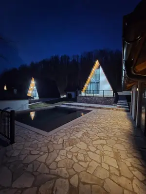 a view of a house with a swimming pool at night at Kozara Resort