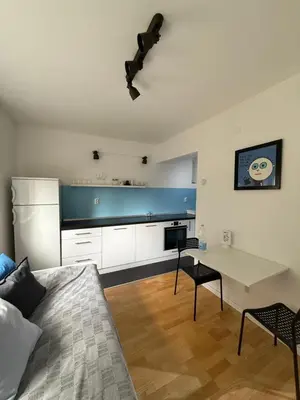 a living room with a bed and a table and a kitchen at Welcome Apartment in Banja Luka