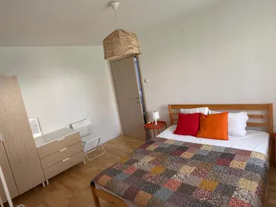 a bedroom with a bed with colorful pillows on it at Welcome Apartment in Banja Luka
