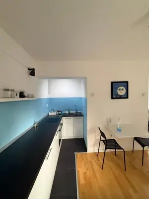 a kitchen with a black and white counter and a table at Welcome Apartment in Banja Luka