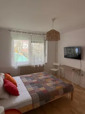a bedroom with a bed with a colorful quilt on it at Welcome Apartment in Banja Luka