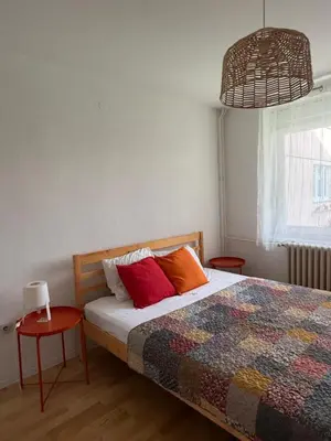 a bedroom with a bed with colorful pillows on it at Welcome Apartment in Banja Luka