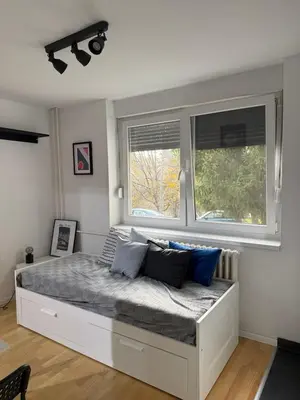 a bed in a room with two windows at Welcome Apartment in Banja Luka