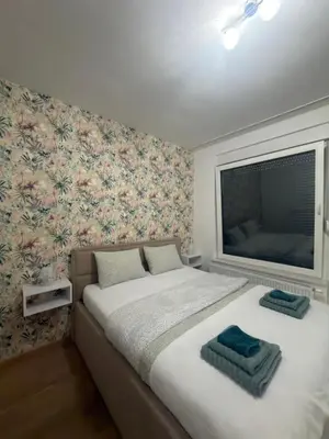 a bedroom with a bed with a large window at Apartman Green Park in Banja Luka