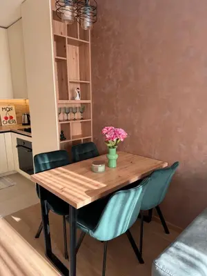 a dining room table with chairs and a vase of flowers at Apartman Green Park in Banja Luka