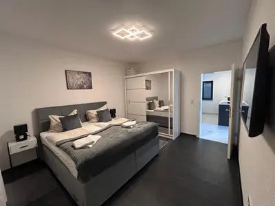 a bedroom with a large bed and a bathroom at Villa Sky in Bosanska Krupa