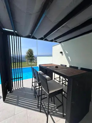 a patio with a table and chairs next to a pool at Villa Sky in Bosanska Krupa
