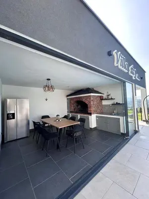 a dining room with a table and a refrigerator at Villa Sky in Bosanska Krupa