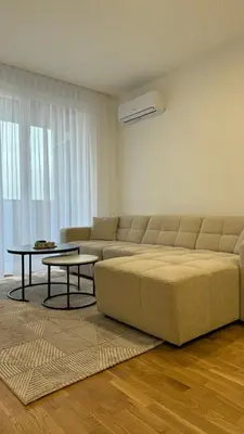 a living room with a large couch and a table at Stela Stan Na Dan Banja Luka in Banja Luka