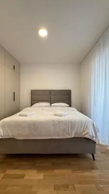 a bedroom with a large bed with white sheets at Stela Stan Na Dan Banja Luka in Banja Luka
