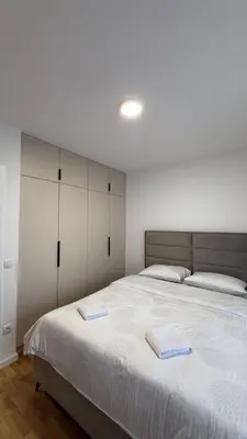 a bedroom with a large bed with two towels on it at Stela Stan Na Dan Banja Luka in Banja Luka