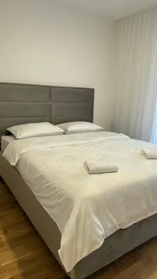 a large bed with white sheets and pillows on it at Stela Stan Na Dan Banja Luka in Banja Luka