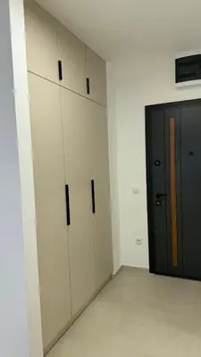 a room with white cabinets and a black door at Stela Stan Na Dan Banja Luka in Banja Luka
