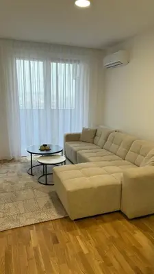a living room with a couch and a table at Stela Stan Na Dan Banja Luka in Banja Luka
