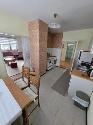 a kitchen and living room with a table and chairs at Apartman Daki in Vareš