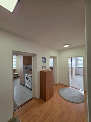 an empty living room with a refrigerator and a kitchen at Apartman Daki in Vareš