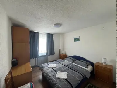 a bedroom with a large bed and a window at Kuća za odmor Kuna in Kupres