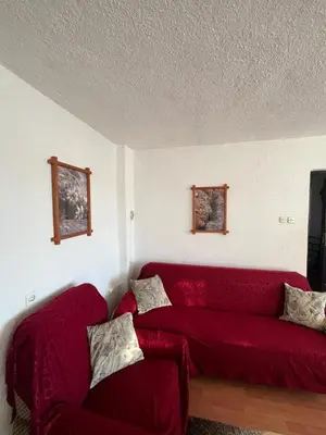 a living room with a red couch in a room at Kuća za odmor Kuna in Kupres