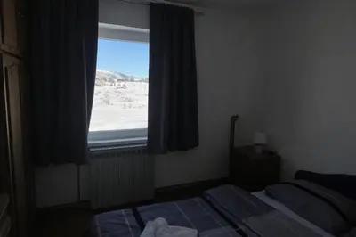 a bedroom with a bed and a large window at Kuća za odmor Kuna in Kupres
