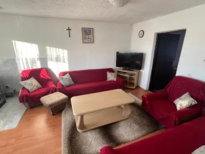 a living room with two red couches and a tv at Kuća za odmor Kuna in Kupres