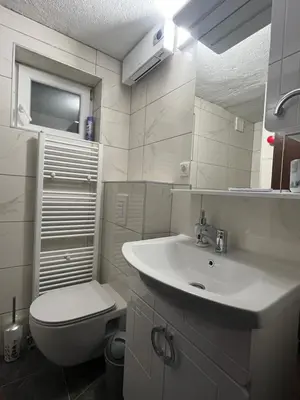 a white bathroom with a toilet and a sink at Kuća za odmor Kuna in Kupres